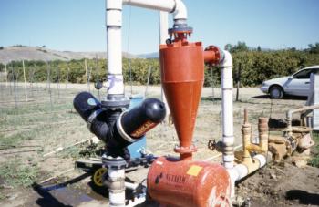Centrifugal sand separator and disk filter on a vineyard drip irrigation system.  Photo:  L. Schwankl